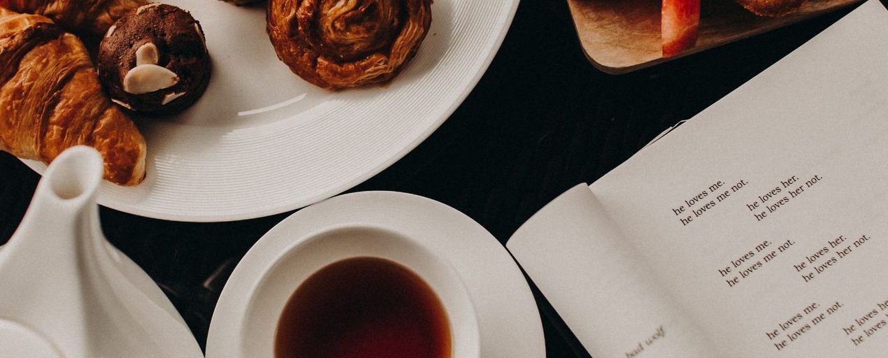 A delightful breakfast arrangement featuring croissants, pastries, and a cup of tea for a cozy morning.